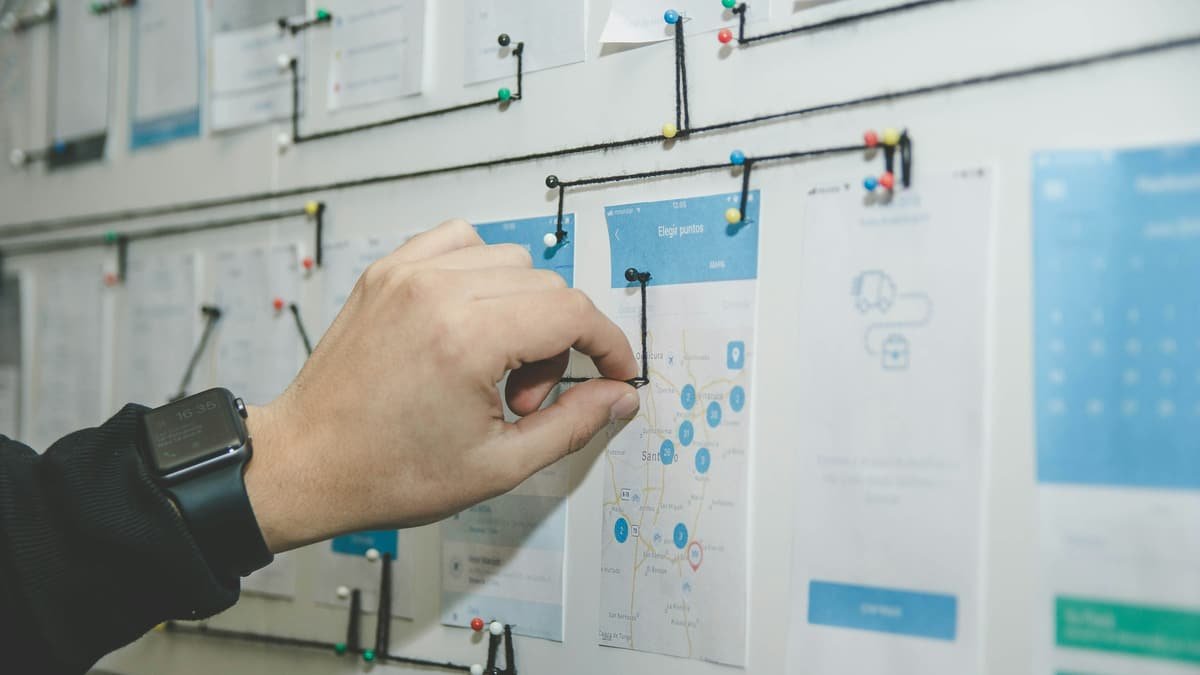 Hand-drawn page wireframes pinned to a wall while being annotated